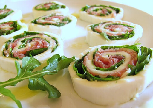 Rolls of mozzarella and raw ham